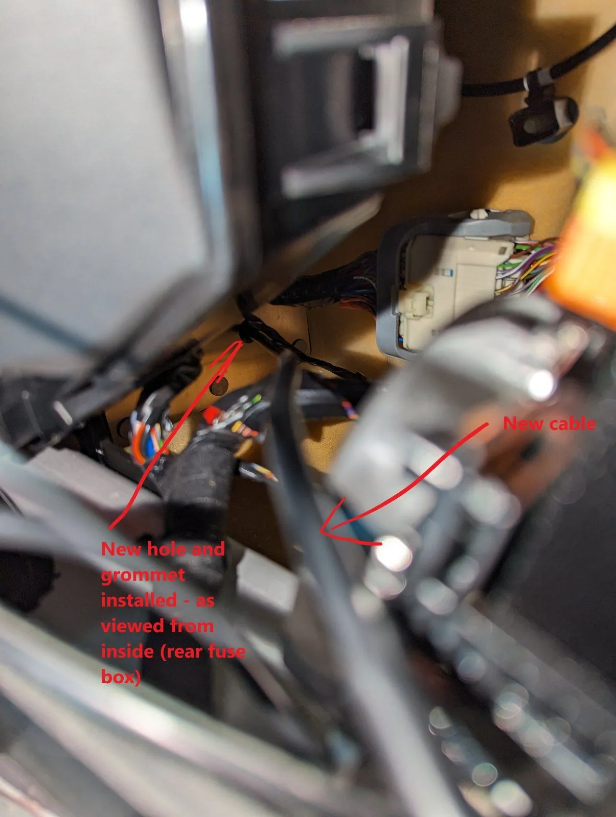 Installed cable and grommet (view from inside the car, in the rear fuse box compartment)